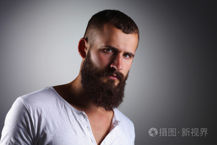 英俊的大胡子男人站,灰色的 bac 上孤立的肖像
