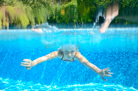 孩子在游戏和快乐，水下和视图上方的游泳池游泳