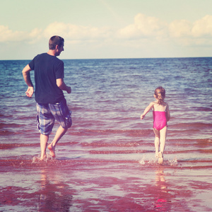 父亲和小女孩在玩水中