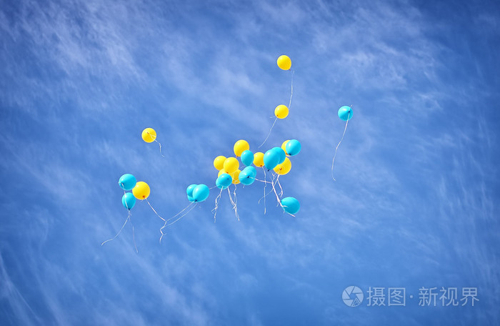 黄色和蓝色气球飞在天空中