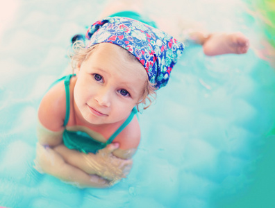 在游泳池里的小女孩的微笑着夏天
