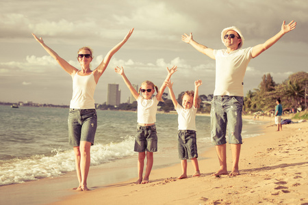 幸福的家庭站在海滩上在白天的时间