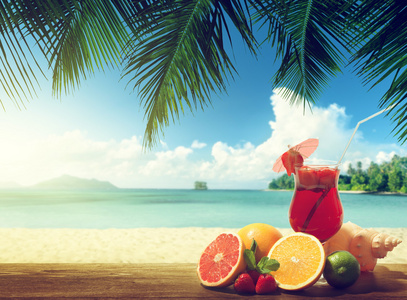 在海滩上的草莓鸡尾酒和热带水果