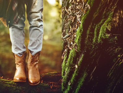 秋天的牛仔风格。在树林里的牛仔靴