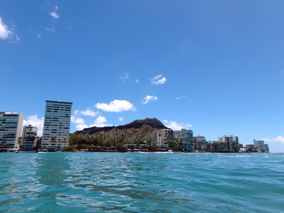 威基基的海浪拍打着海堤与椰林树影，朝着公寓 bui