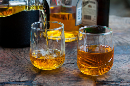 在玻璃中的岩石上金棕色威士忌