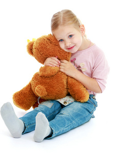 小女孩抱着一只玩具熊