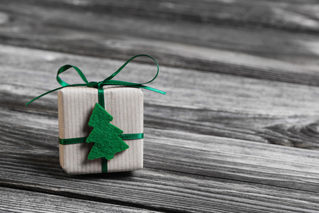 一个绿色圣诞礼物上木制的灰色背景