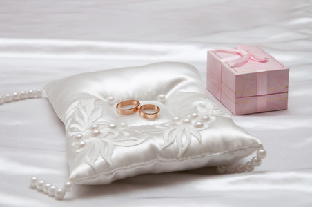 在白色的枕头上的结婚戒指图片