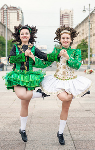两个妇女在爱尔兰舞蹈服装和假发跳舞