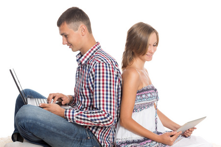 年轻夫妇使用一台笔记本电脑和平板电脑