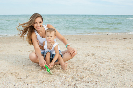 母亲和她的儿子在沙滩上玩