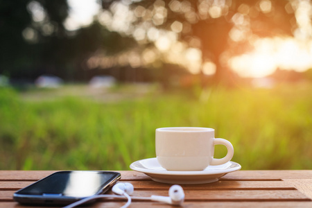 咖啡杯和日落的时候，桌上的智能手机