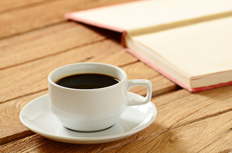 一杯咖啡和木制的桌子上的书