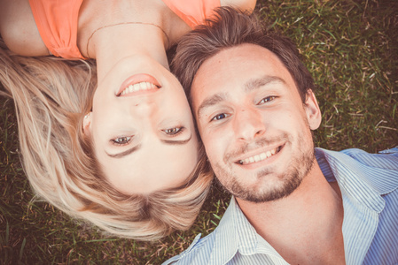 幸福的情侣躺在草地上的特写镜头