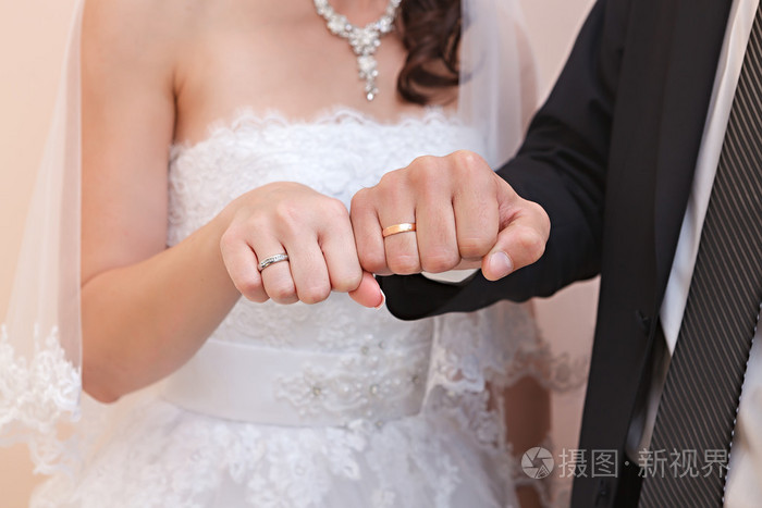 新郎和新娘在婚礼上的结婚戒指的手