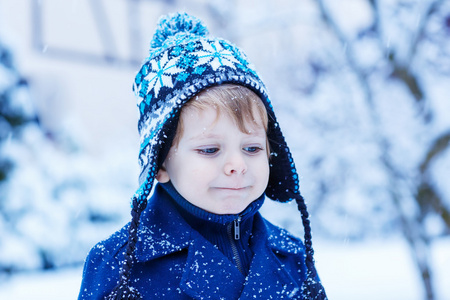 小孩子的落雪的冬天衣服的肖像