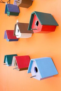 五彩鸟的巢木盒子上橙色墙背景装饰