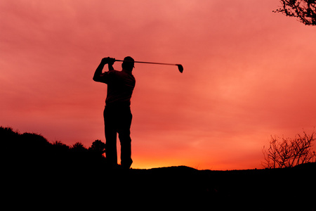 在夕阳映衬的高尔夫球手