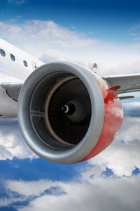 飞机飞过云层的红色引擎图片