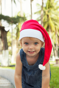 可爱的女孩在圣诞老人的帽子在热带鱼的开心