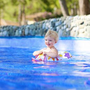 小女孩在度假村的游泳池里游泳图片