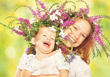 快乐的女儿笑着抱着母亲在花圈里的夏天