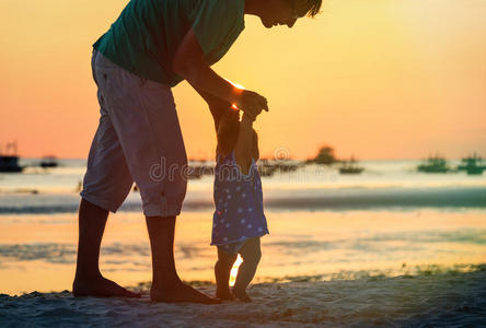 日落海滩上父女的剪影