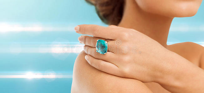 戴着蓝色鸡尾酒戒指的女人手的特写镜头