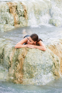 年轻女子躺在天然的游泳池，结束，意大利