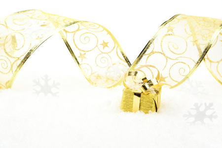 用金色丝带在雪上的金色圣诞礼物