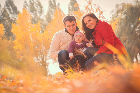 快乐年轻的家庭在秋天公园花时间户外