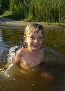 阳光明媚的日子里，小女孩在水中快乐地微笑