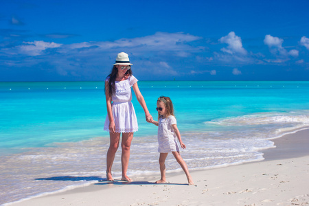 快乐妈妈和小女儿在热带海滩有乐趣
