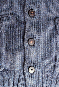 暗蓝色针织套头毛衣与背景的按钮
