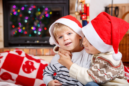 两个小兄妹男孩在圣诞老人的帽子，室内的肖像