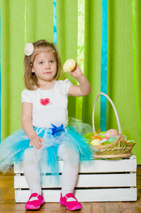 小女孩提着一个篮子与复活节彩蛋