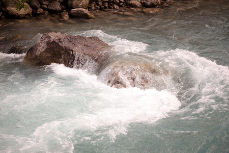 绿水的山区河流和一块大石头