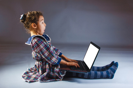 女孩子在一个穿着灰色背景看计算机