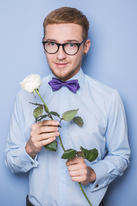 浪漫的英俊青年抱着玫瑰一朵。日期，生日，情人节