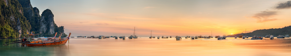 日落与色彩斑斓的天空，在海滩上的小船