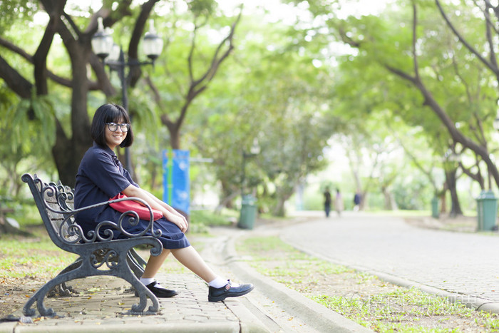 戴着眼镜坐在长椅上的女孩