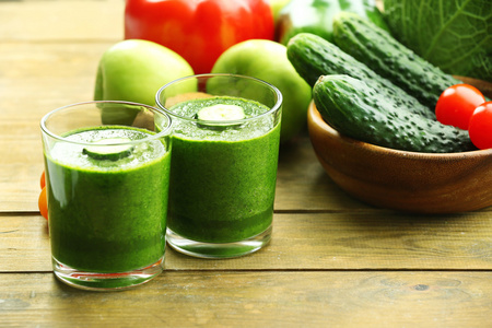 绿色新鲜健康果汁与水果和蔬菜上木桌背景