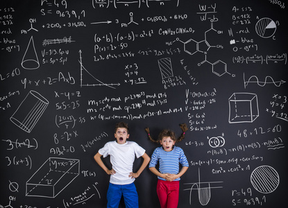 男孩和女孩在一块黑板前面学习图片