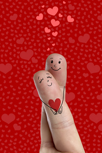 手指艺术对幸福的夫妻。情人是拥抱，拿着红色的心。股票的图像