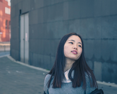 在城市的街道构成的年轻漂亮的中国女孩