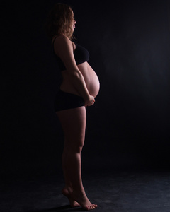 一名孕妇在不同位置的一个摄影棚里拍摄