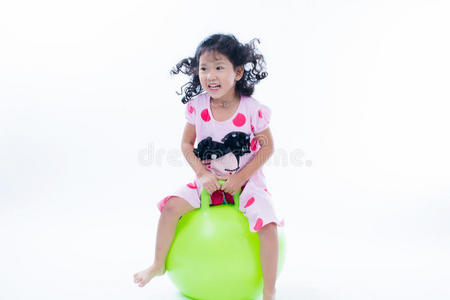 快乐的小女孩跳在弹跳的球上