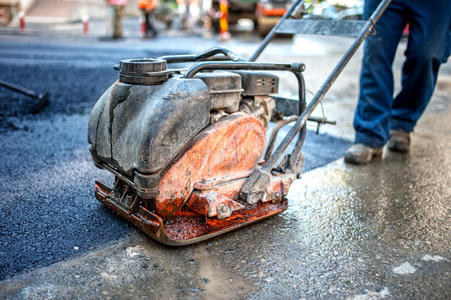 道路施工现场沥青工带压路机板