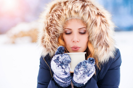 女人在雪地上一杯咖啡